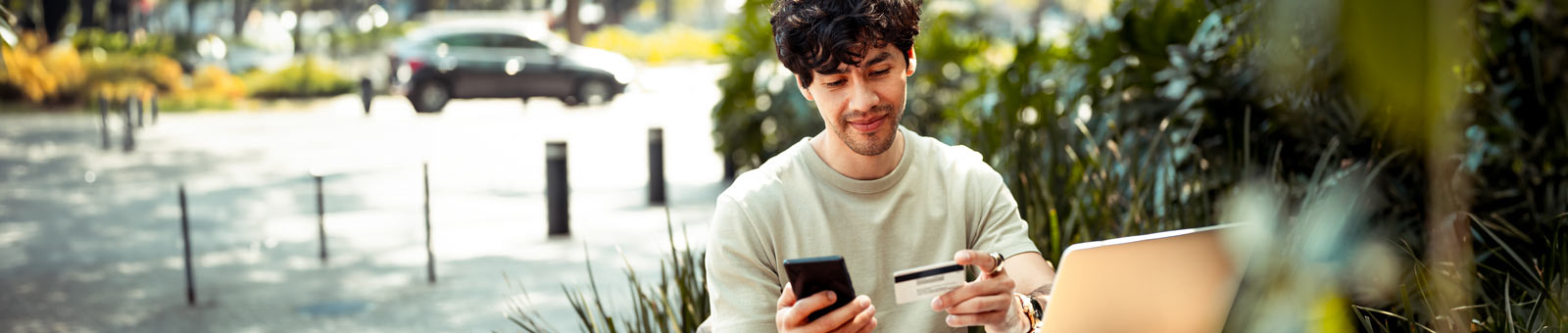 Man holding mobile phone in one hand and credit card in other