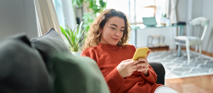 Woman on couch using smartphone