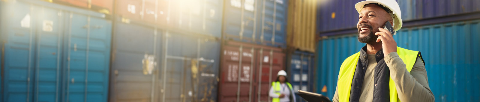 Man on phone near containers