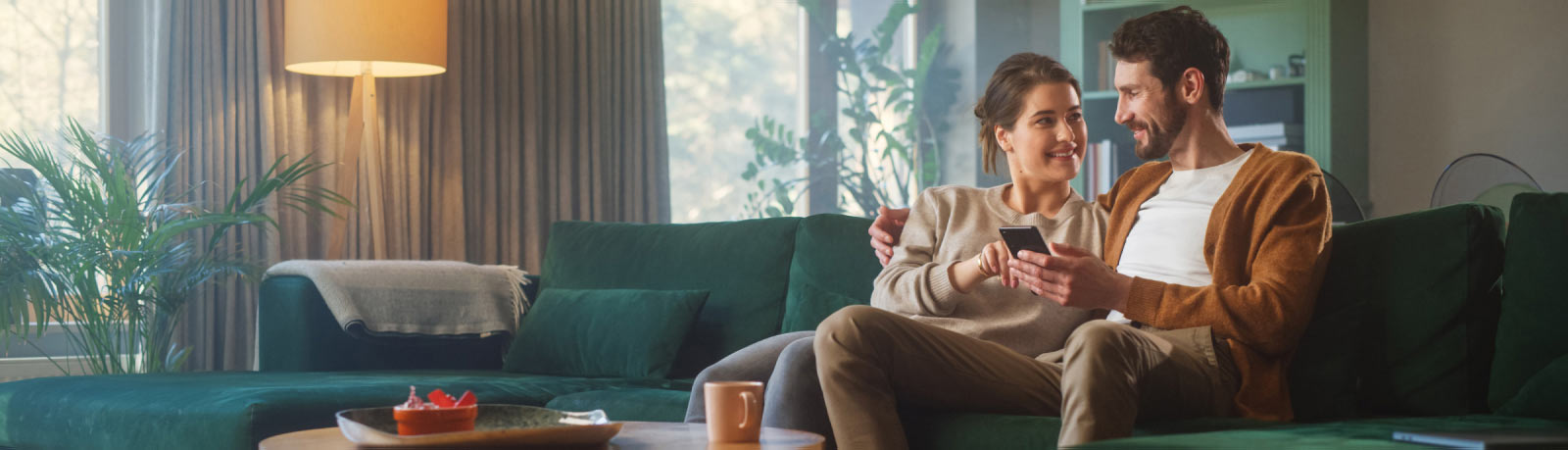 Couple using a smartphone while sitting on a sofa