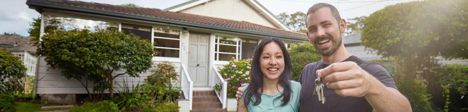 Couple in front of house with keys