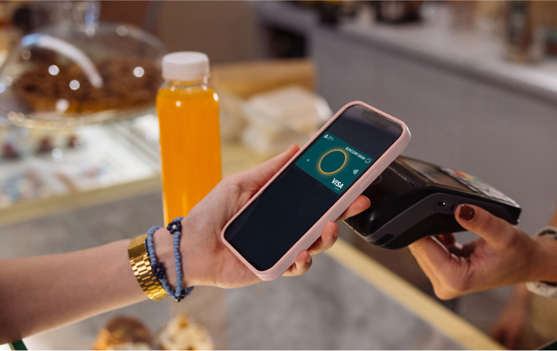 A Suncorp Bank customer using contactless payment at a cafe