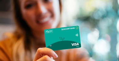 A woman holding a Carbon Neutral Visa Debit card